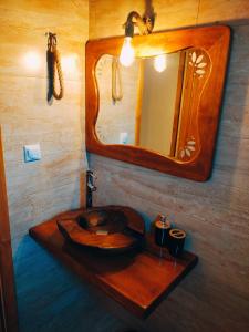 ein Badezimmer mit einem hölzernen Waschbecken und einem Spiegel in der Unterkunft ACHILLEAS PEACEFUL PLACE in Skála Sikiás