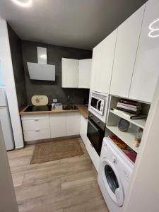 a kitchen with white cabinets and a washing machine at CORNELIAS HOME 1A between LAS VISTAS & LOS CRISTIANOS BEACH in Los Cristianos