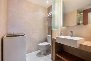 uma casa de banho com um lavatório branco e um WC. em Sanya Yikehai View Apartments em Sanya