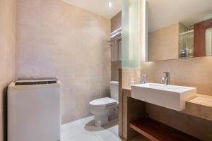 a bathroom with a white sink and a toilet at Sanya Yikehai View Apartments in Sanya