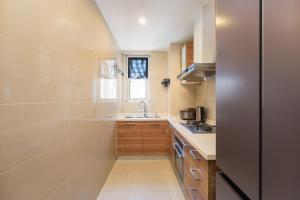 a small kitchen with a sink and a stove at Sanya Yikehai View Apartments in Sanya