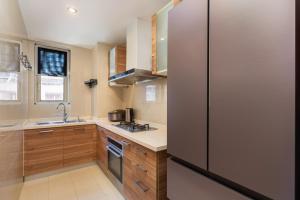 cocina con nevera y fregadero en Sanya Yikehai View Apartments en Sanya