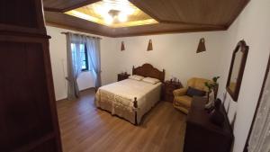 ein Schlafzimmer mit einem Bett und einem Stuhl in einem Zimmer in der Unterkunft Casa da Rosa Porreiras in Paredes de Coura + 32 Fotos