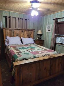 1 dormitorio con cama de madera y cabecero de madera en Butler's Bay Cottage cottage, en Hayward