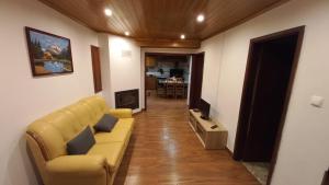 ein Wohnzimmer mit Sofa und Fernseher in der Unterkunft Casa da Rosa Porreiras in Paredes de Coura