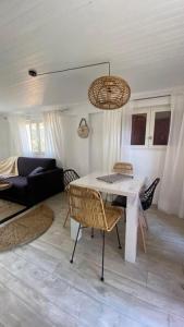 Una sala de estar con una mesa y sillas blancas. en Casa Francesca, en Saint-Florent
