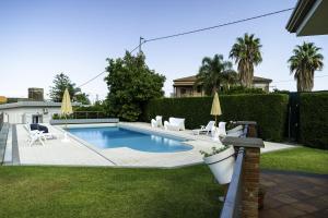 - une piscine dans une cour avec des chaises dans l'établissement Tropical House, à San Leonardello