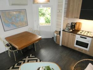 a small kitchen with a wooden table and a dining room at Studio Cosy proche Grand-Champ Home Sweet Home in Plumergat