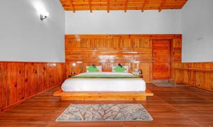 マックトシュワーにあるTreebo Trend Om Villa With Mountain Viewの木製の壁のベッドルーム1室(ベッド1台付)