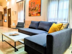 uma sala de estar com um sofá azul e uma mesa em Apartamento Alfarería em Sevilha
