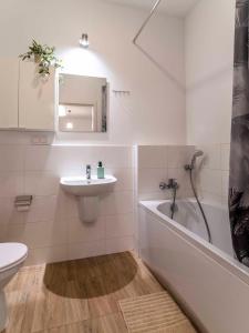 a bathroom with a sink and a tub and a toilet at FIRST - Green Żoliborz Apartment 6 in Warsaw