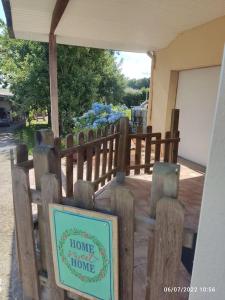 a wooden fence with a sign that reads home a home a home at Studio Cosy proche Grand-Champ Home Sweet Home in Plumergat