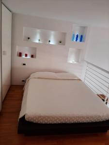 1 dormitorio blanco con 1 cama grande y 2 luces en Il Nido Bilocale Niguarda, en Milán