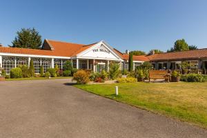 un gran edificio blanco con un banco delante en The Bridge Hotel and Spa, en Wetherby