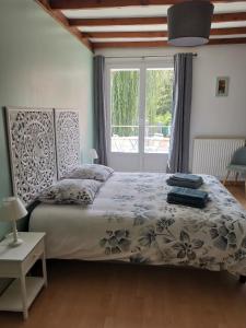 um quarto com uma cama e uma grande janela em Le Moulin d'Audenfort em Clerques