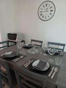 uma mesa com cadeiras e um relógio na parede em Boville Family House em Boville Ernica