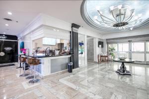 a living room with a kitchen and a ceiling with a chandelier at Perfect Panorama - #905B in Fort Lauderdale