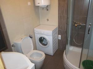 a bathroom with a toilet and a washing machine at Apartment Kiki in Zlatibor