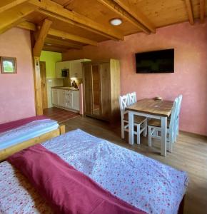 a bedroom with a table and a dining room at Penzion Major in Rokytnice nad Jizerou