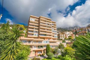 un grand immeuble situé sur une colline arborée dans l'établissement Baie de Monaco, Vue Mer, Terrasse, Parking Gratuit - AF, à Beausoleil