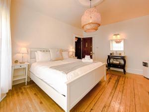 1 dormitorio con 1 cama blanca grande y escritorio en Hotel du Vieux Port by Bower Boutique Hotels, en Shediac
