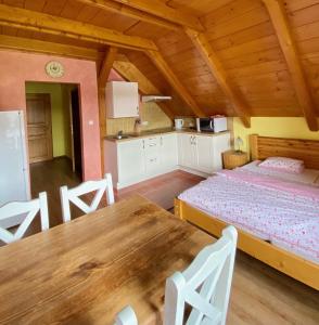 ein Esszimmer mit einem Tisch und einem Bett in einem Zimmer in der Unterkunft Penzion Major in Rokytnice nad Jizerou