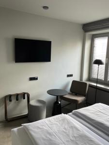 a bedroom with a bed and a tv on the wall at Hotel Mons am Goetheplatz in Munich