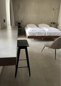 ミュンヘンにあるホテル モンス アム ゲーテプラッツのテーブル、ベッド、椅子が備わる客室です。