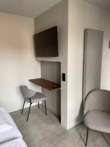 a bedroom with a desk and a chair and a tv at Hotel Mons am Goetheplatz in Munich