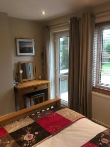 a bedroom with a bed and a tv and a window at Seaside Stay in Rustington