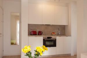 a kitchen with white cabinets and yellow flowers in a vase at Lovely beachfront apartment in Calahonda in Sitio de Calahonda +6 photos
