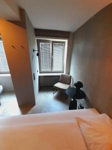 1 dormitorio con 1 cama, 1 silla y 1 ventana en Hotel Mons am Goetheplatz, en Múnich