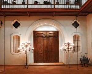a large wooden door in a room with two chandeliers at Parador Santa Maria La Real in Sucre
