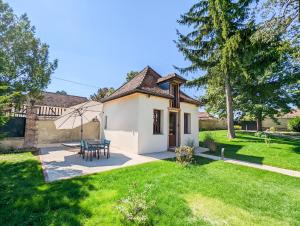 ein Haus mit einer Terrasse und einem Tisch im Hof in der Unterkunft La Maison T&M in Dosches