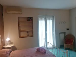 una camera con letto, finestra e sedia di Palmarosa Apartments superior a Ercolano