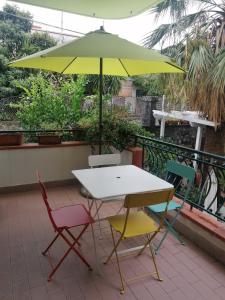 un tavolo e sedie sotto un ombrellone su un balcone di Palmarosa Apartments superior a Ercolano