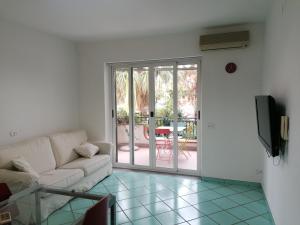 un soggiorno con divano e porta scorrevole in vetro di Palmarosa Apartments superior a Ercolano