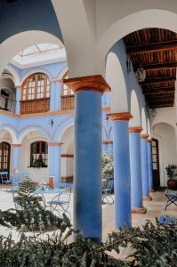 スクレにあるParador Santa Maria La Realの青い柱とテーブルと椅子が並ぶ建物