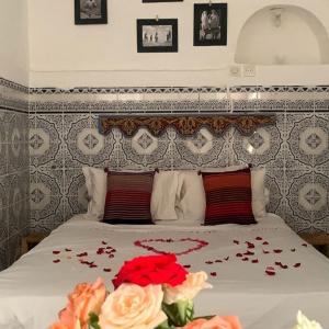 ein Schlafzimmer mit einem Bett mit Blumen darauf in der Unterkunft Hannah House Marrakech in Marrakesch