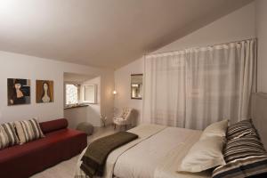 オルヴィエートにあるアパルタメント マナッセイのベッドルーム1室(ベッド1台、赤いソファ付)