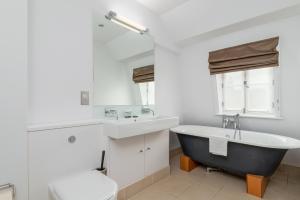 La salle de bains est pourvue d'une baignoire, d'un lavabo et de toilettes. dans l'établissement A Stunning Three Bedroom Home in Mayfair, à Londres
