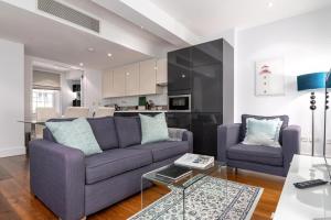 a living room with a couch and a table at A Stunning Three Bedroom Home in Mayfair in London