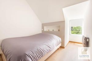 a white bedroom with a bed and a window at Residence Poterne in Valenciennes