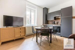 cocina con mesa y sillas y TV en Residence Poterne en Valenciennes