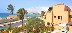 a view of a building and the ocean at Holiday flat BLUE OCEAN, beachfront, sea view, 1 bedroom, livingroom, fast internet in Costa Calma