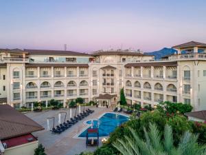 un gran edificio con una piscina frente a él en Savoy Hotel Spa & Casino en Kyrenia