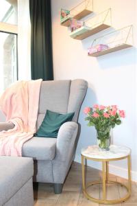 uma sala de estar com um sofá e uma mesa com um vaso de flores em JODEŁKA Apartament & Studio em Świeradów-Zdrój