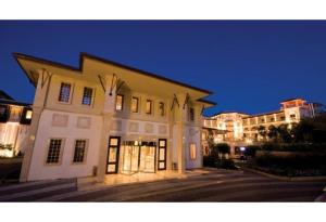 - un grand bâtiment blanc avec des lumières la nuit dans l'établissement Savoy Hotel Spa & Casino, à Kyrenia