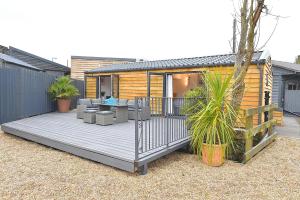 een huis met een terras met een tafel en stoelen bij Cheerful 1BD Cottage with Parking Nr Guildford in Guildford