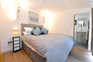 a bedroom with a large bed and a mirror at Cheerful 1BD Cottage with Parking Nr Guildford in Guildford